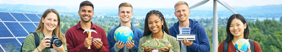 Sechs junge Erwachsene stehen im Freien vor einer Landschaft mit Windrad und Solarpaneelen. Sie lächeln in die Kamera und halten verschiedene Gegenstände in den Händen, darunter eine Kamera, einen Hammer, ein Modell der Erde, ein Gesteinsmodell sowie ein kleines Solarpanel. Im Hintergrund sind grüne Hügel und ein weiter Himmel zu sehen. Die Szene vermittelt einen Bezug zu Geowissenschaften, Umwelt und erneuerbaren Energien.