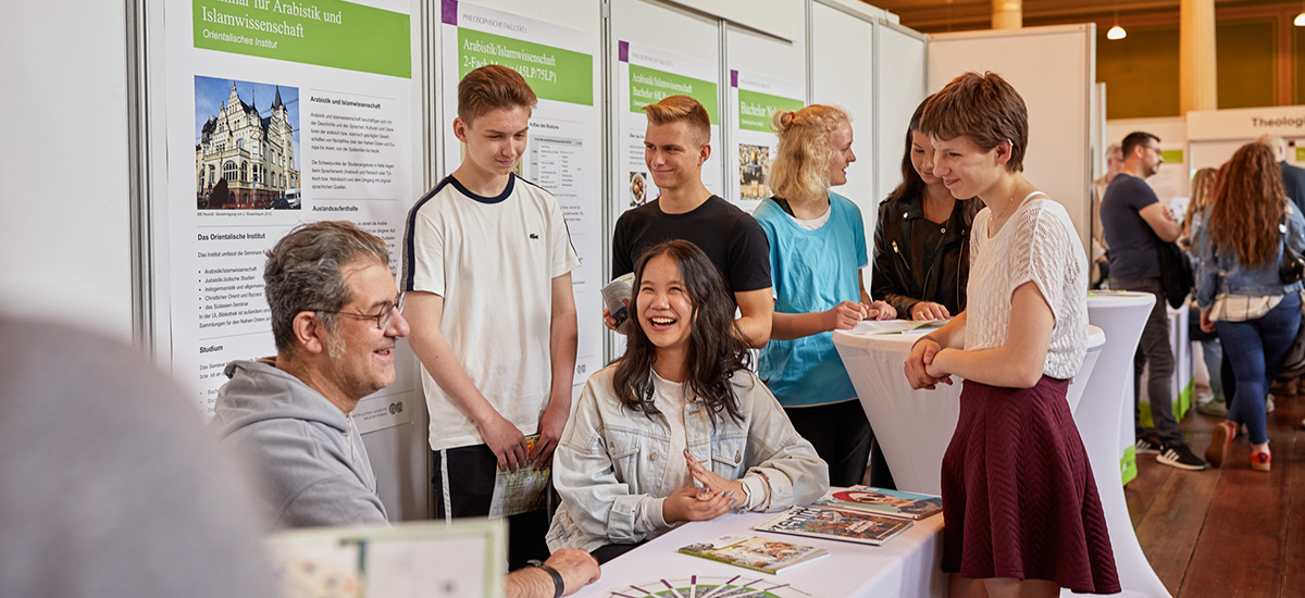 Studieninteressierte beim Gespräch am Infostand.