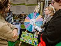 Bei der Stabsstelle Vielfalt und Chancengleichheit konnten Studierende spielerisch über das gleichnamige Thema ins Gespräch kommen. Eine Person dreht am Glücksrad, weitere Personen schauen zu. (Bild öffnet vergrößert)