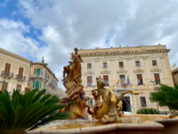 Foto: Der Diana-Brunnen mit der Bank von Sizilien im Hintergrund auf der Piazza Archimede.