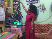 Zu sehen ist Mercy neben einem kleinen Weihnachtsbaum in ihrem Zuhause in Tamil Nadu.
