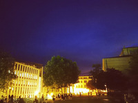 Der Uniplatz bei Nacht, alles ist hell erleuchtet und die Menschen schlendern über den Pflasterstein (Bild öffnet vergrößert)