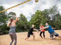 Das Foto zeigt Studierende beim Beachvolleyball spielen. (Bild öffnet vergrößert)