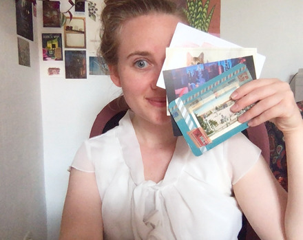 Ich an meinem Schreibtisch mit 4 Postkarten in der Hand