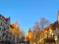Foto: Eine der Straßen im Paulusviertel und im Hintergrund steht die wunderschöne Pauluskirche im Sonnenlicht.