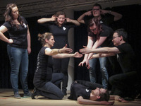 Händels Harlekine performen auf einer Bühne, alle sind komplett schwarz gekleidet. (Bild öffnet vergrößert)