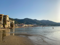 Foto: Traumhafte Strand in Cefalù mit den alten italienischen Gebäuden daneben.