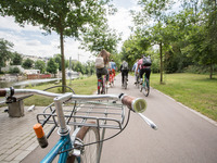 Das Bild zeigt den Blick über einen Fahrradlenker auf eine Gruppe von Radfahrern. 