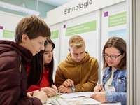 Eine Dozentin berät Jugendliche am Infostand der Ethnologie.  (Bild öffnet vergrößert)