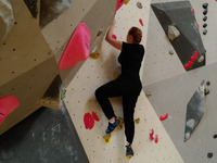 Ich klettere einen einfachen gelben Weg in der Boulderhalle.