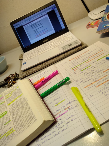 zu sehen ist ein Laptop und Notizen auf einem Schreibtisch.