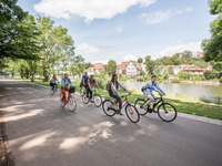 Junge Menschen radeln mit ihren Fahrrädern am Fluss entlang. (Bild öffnet vergrößert)