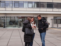 Foto: Zu sehen sind drei Personen, die im Halbkreis zueinander stehen. Hinter ihnen befindet sich das Fraunhofer Institut am Weinberg Campus. (Bild öffnet vergrößert)