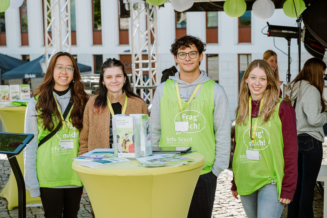Vier Personen lächeln in die Kamera. Vier Personen lächeln in die Kamera.
