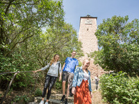 Junge Menschen kommen eine Treppe am Giebichenstein herunter. Im Hintergrund ragt der weithin sichtbare Torturm der Oberburg auf.