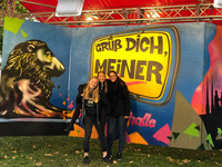 Ich und zwei weitere Studienbotschafterinnen vor einer Fotoleinwand mit der Aufschrift "Grüß dich meiner" (Bild öffnet vergrößert)